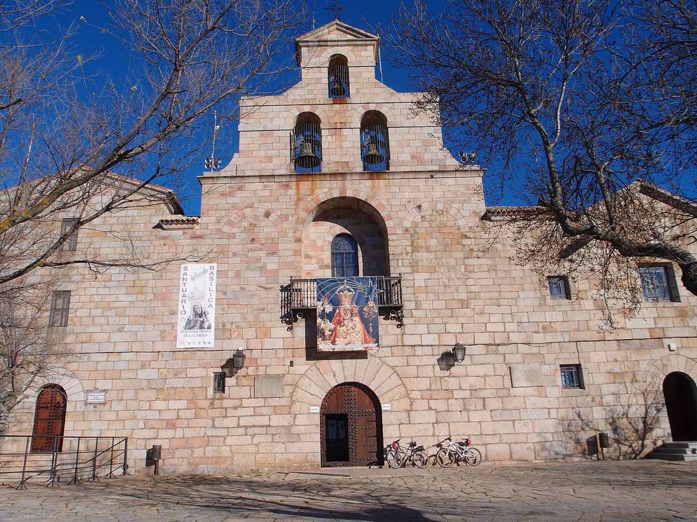 Fachada de piedra de la Basílica de la Virgen de la Cabeza, con su espadaña de campanas.