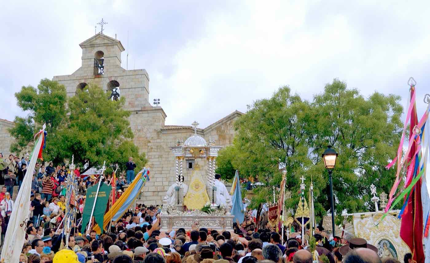 Las andas de la Virgen llegan a la explanada del Santuario entre banderas de cofradías y una multitud de romeros.