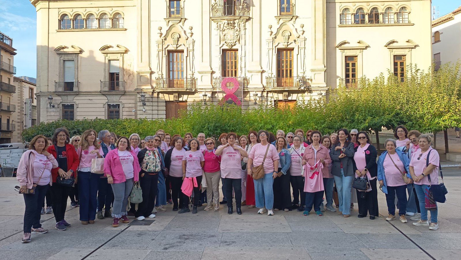 Imagen de la noticia: Un lazo rosa de flores tejidas por vecinas cubre la fachada del Ayuntamiento de Jaén